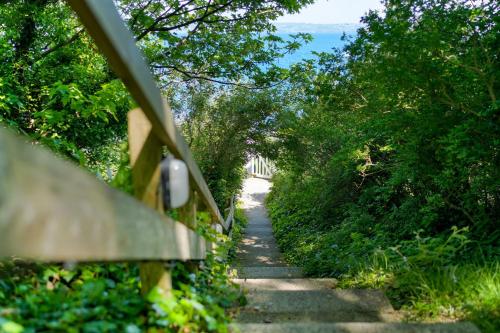 a stone path with trees and a fence at 1 The Old Signal House, Penlee Point in Torpoint