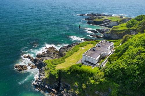 an aerial view of a house on a island in the ocean at 1 The Old Signal House, Penlee Point in Torpoint