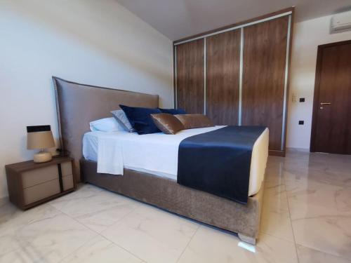 a bedroom with a large bed with blue pillows at Luxury Apartment Olea Afandou in Afantou