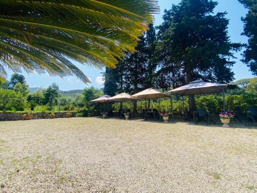 a patio with umbrellas and tables and chairs at Villa Gaia in Portoferraio