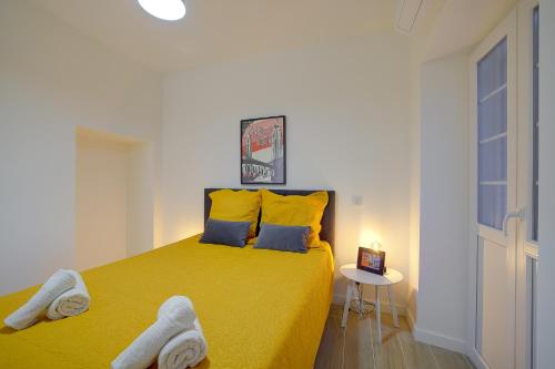 - une chambre avec un lit jaune et des serviettes dans l'établissement Maison Bianchi - Jaures Old Town, à Nice