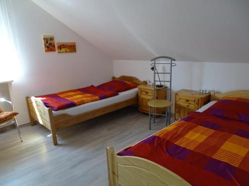 奈拉的住宿－Ferienwohnung Schmidt, Wohnung 2，一间卧室配有两张床、一张桌子和一把椅子