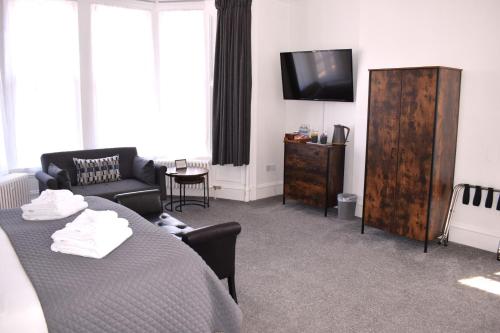 a living room with a table and a tv at Woodlyn Guest House in Gatehouse of Fleet