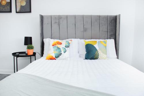 Una cama con sábanas blancas y almohadas. en Awesome 2 bed flat in Liverpool!, en Liverpool