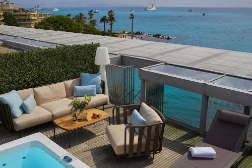 a patio with a couch and a swimming pool at Royal Antibes - Luxury Hotel, Résidence, Beach & Spa in Antibes