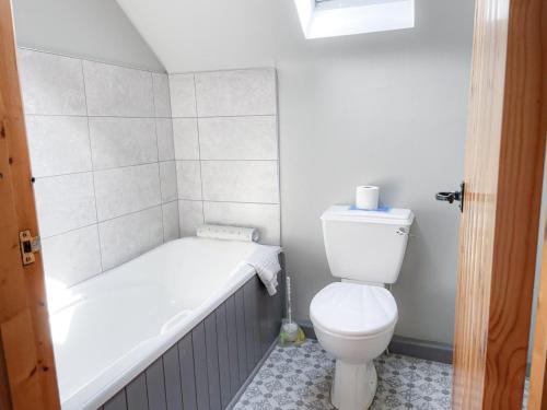 a bathroom with a toilet and a bath tub at Sweetbriar Holiday Cottage by Trident Holiday Homes in Kilmore Quay