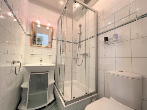 uma casa de banho com um chuveiro, um WC e um lavatório. em Ferienpark Sierksdorf App 15 - Strandlage em Sierksdorf
