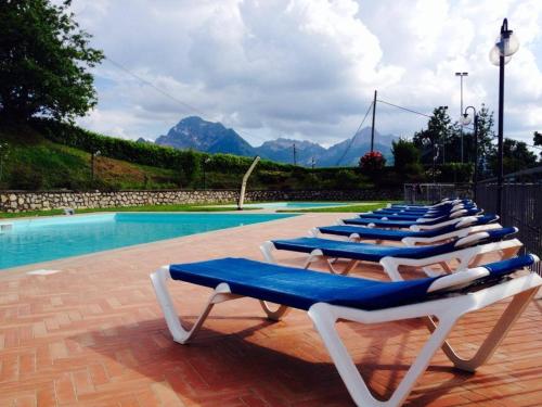 a row of lounge chairs next to a swimming pool at Albergo Ristorante Belvedere in Minucciano