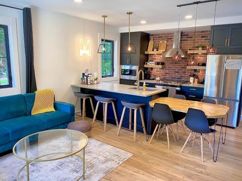 cocina y sala de estar con sofá azul en Stylish Downtown Kingsville Getaway with Putting Green, Firepit & Games en Kingsville