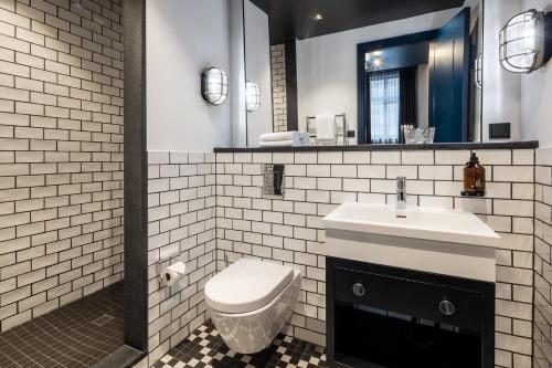 a bathroom with a toilet and a sink and a mirror at Hotel AMO by AMANO Friedrichstraße in Berlin