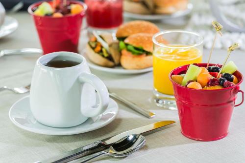 a table with a cup of coffee and a bowl of fruit at Renaissance Santiago by Marriott in Santiago