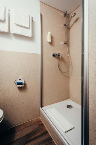 a bathroom with a shower and a toilet at Hotel Adler in Eichstätt