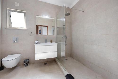uma casa de banho com um chuveiro, um WC e um lavatório. em Mar e Campo em Barão de São João