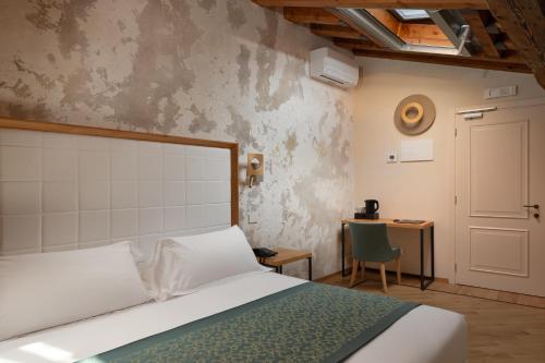 ein Schlafzimmer mit einem Bett und einem Tisch mit einem Stuhl in der Unterkunft Cà Uberti Palace Hotel in Mantua