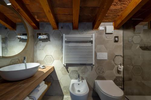 uma casa de banho com um lavatório branco e um WC. em Cà Uberti Palace Hotel em Mantova