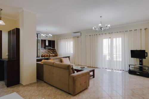 a living room with a couch and a tv at Hotel Milo Ksamil in Ksamil