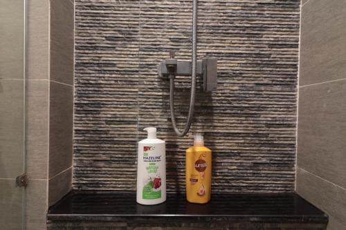 two bottles ofodorizers sitting on a shelf in a shower at Deluxe apartment with balcony, pool, fitness and yoga in Ho Chi Minh City