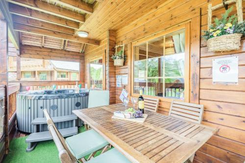 a dining room with a wooden table and chairs at Robin Lodge in Llanbedr