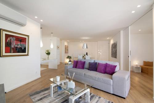 a living room with a couch and purple pillows at Mare Nostrum in Olhão