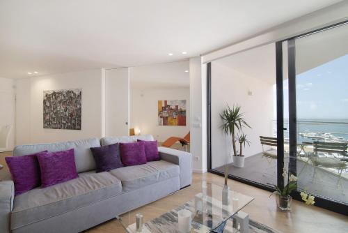 - un salon avec un canapé et des oreillers violets dans l'établissement Mare Nostrum, à Olhão