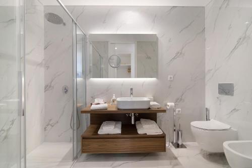 La salle de bains est pourvue d'un lavabo, de toilettes et d'une douche. dans l'établissement Mare Nostrum, à Olhão