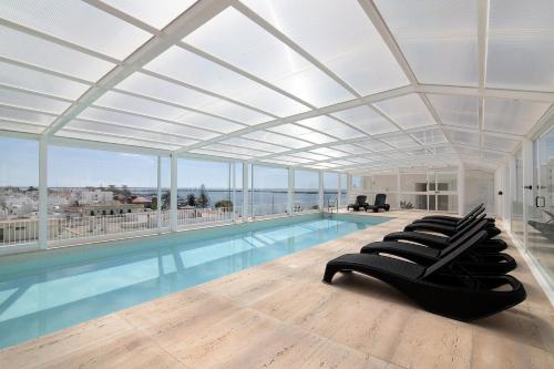 a large swimming pool with a large room with a large ceiling at Mare Nostrum in Olhão