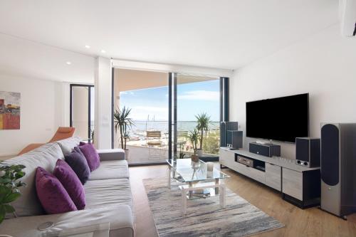 a living room with a couch and a flat screen tv at Mare Nostrum in Olhão