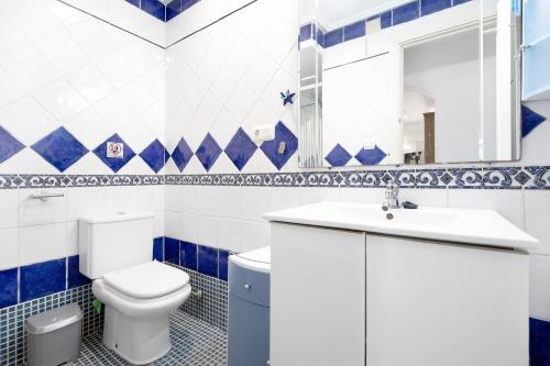 a blue and white bathroom with a toilet and a sink at Finca Novo Sancti Petri in Chiclana de la Frontera
