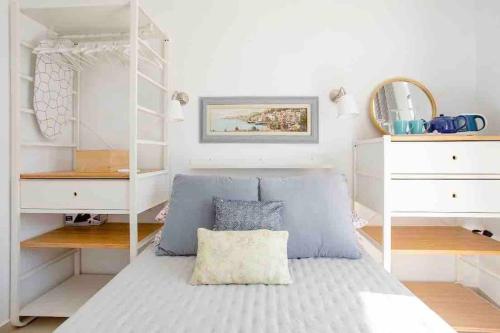 a bedroom with a bed and white shelves at Little Blue House in Marsalforn