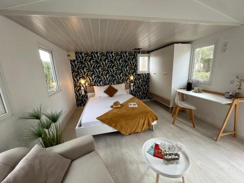 ein Schlafzimmer mit einem Bett, einem Sofa und einem Tisch in der Unterkunft Camping Le Calypso 5 étoiles in Torreilles