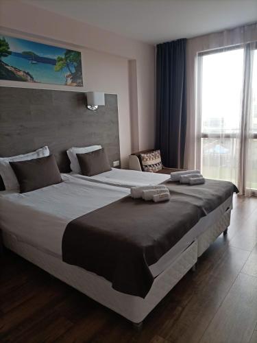 a large bed in a bedroom with a large window at Hotel Vanilla, Varna - Free parking in Varna City
