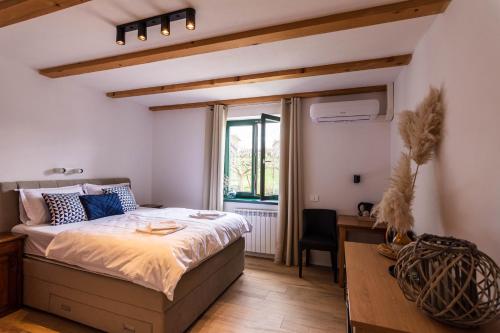 um quarto com uma cama, uma secretária e uma janela em Rooms&Vinery Bregovi - Sobe in vinska klet Bregovi em Dobravlje