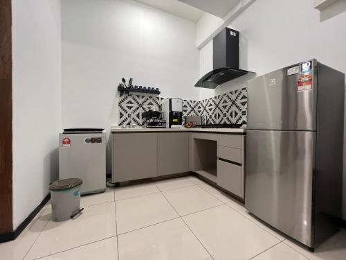 a kitchen with a stainless steel refrigerator and a trash can at Opus Residences KL 118 View in Kuala Lumpur