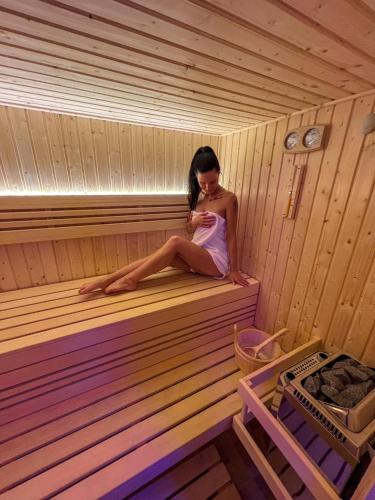 a woman sitting on the inside of a sauna at Resort LUFT Sněžník in Sněžnik
