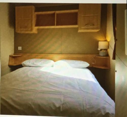 1 cama con sábanas blancas y almohadas en una habitación en Rio Plot F en Torquay