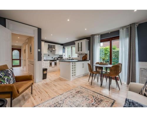 a kitchen and living room with a table and chairs at Central Belfast Apartments Windsor in Belfast