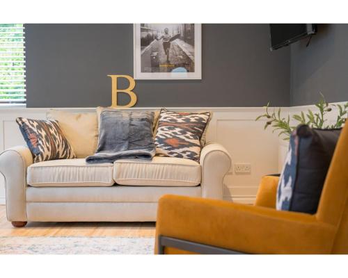 a living room with a couch and a chair at Central Belfast Apartments Windsor in Belfast