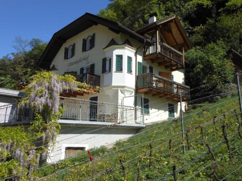 un edificio blanco con balcones en una colina en Ottenkellerhof en Bolzano