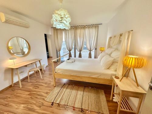 a bedroom with a bed and a mirror and a table at Amazing Luxury Villa Larnaca in Aradhippou