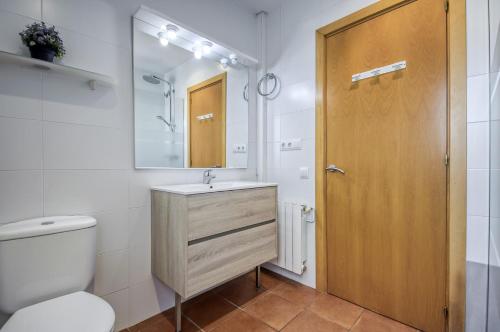 een badkamer met een wastafel, een toilet en een spiegel bij Gregal Atico Roses - Immo Barneda in Roses