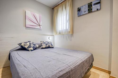 1 dormitorio con cama y ventana en Gregal Atico Roses - Immo Barneda, en Roses