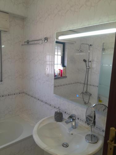 a bathroom with a sink and a mirror and a tub at Beach,surf, hiking and more in Maceira