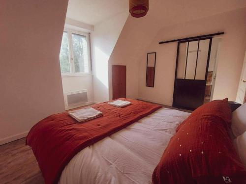 a bedroom with a large bed with a red blanket at L'échappée, Chambres et Tables d'hôtes in Saint-Fiacre