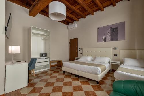 a bedroom with two beds and a desk and a mirror at Residenza Accademia in Mantova