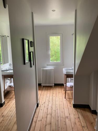 an empty room with a hallway with a window at La suite de la Villa Plume 