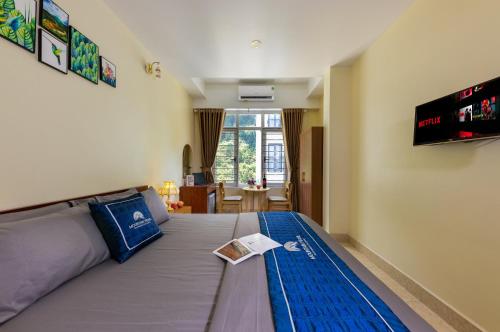 a bedroom with a large bed with a tv on the wall at Mountain Pearl Hotel in Cat Ba