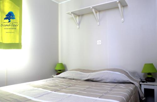 um quarto com uma cama com 2 candeeiros e um cartaz em Mobilhome Sensation Vacances em Sigean