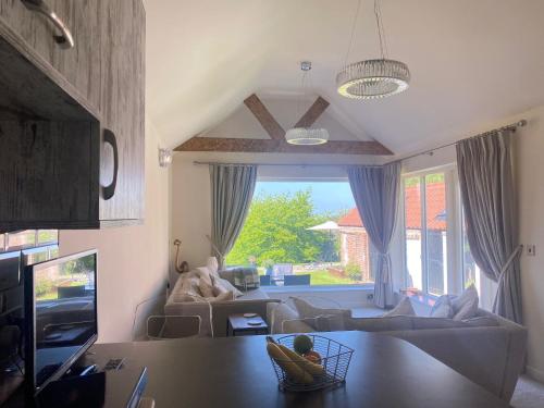 a living room with a couch and a large window at Holly Cottage in Gringley on the Hill