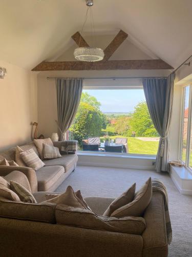a living room with two couches and a large window at Holly Cottage in Gringley on the Hill