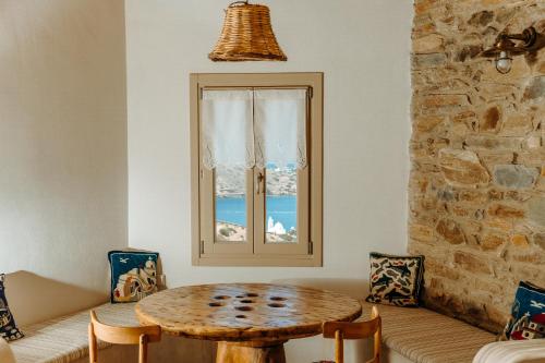 a dining room with a table and a window at Heliopetra Punta in Ios Chora